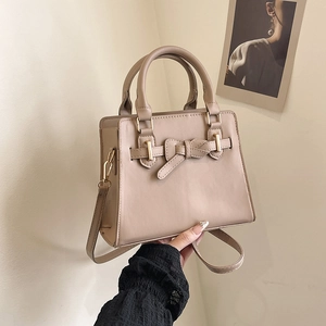 Chic beige crossbody Kelly bag with bow detail and adjustable shoulder strap for women