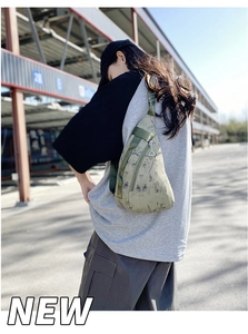 Detail view of army green nylon chest bag with black tie-dye texture and zipper detail