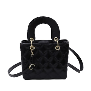 Elegant black quilted handbag with structured top handle and gold hardware on white background