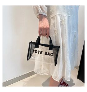 Detail of transparent PVC tote bag featuring black mesh side and Tote Bag print