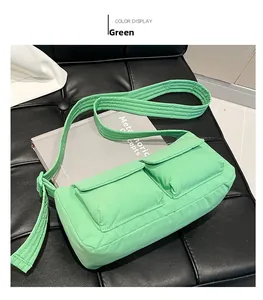 Detail of quilted bright green nylon crossbody bag with dual pockets on a black bench