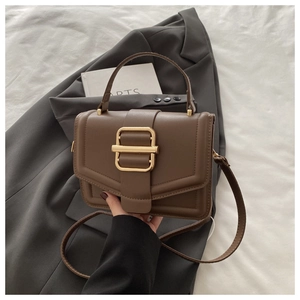 Vue détaillée d'un sac à main en cuir marron avec boucle dorée et poignée