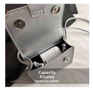 Detail view of silver mini crossbody bag showing magnetic closure and interior capacity