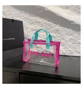 Detail of transparent PVC tote bag with pink mesh edges and blue woven handles