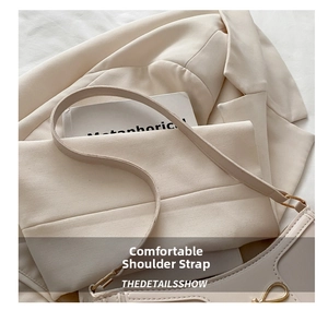 Detailed close-up of cream shoulder bag featuring adjustable strap and gold metal buckle