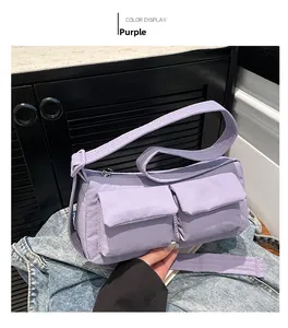 Close-up of purple nylon crossbody bag with utility pockets on a denim jacket