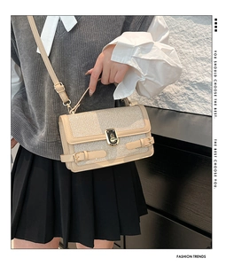 Detail of beige sequin crossbody bag featuring gold twist lock and fine leather strap