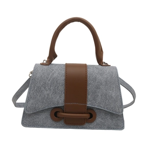 Grey denim texture handbag with brown leather straps and adjustable shoulder strap