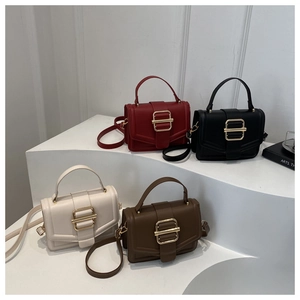 Detail shot of four elegant square handbags in red, black, beige, and brown on white steps