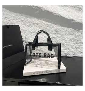 Close-up of black mesh tote bag with TOTE BAG lettering and transparent PVC paneling