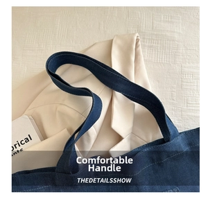 Close-up of reinforced denim tote bag handle with detailed twill texture and stitching