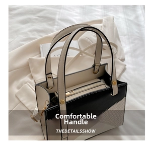 Detail of color-block tote bag with woven panel and metallic gold hardware accents