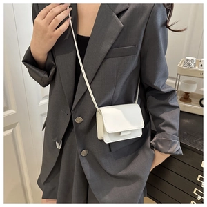 Minimalist white square crossbody bag shown with model for size reference and clean aesthetic
