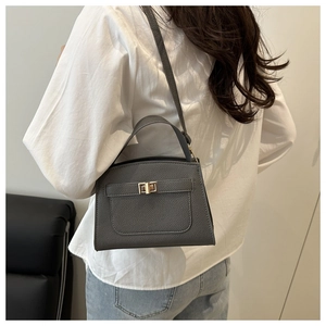 Dark grey pebble leather handbag with gold twist lock shown in a daily wear style