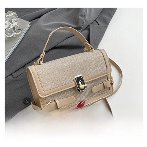 Close-up of beige woven crossbody bag with golden rotary lock and buckle straps