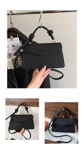 Détail du petit sac carré noir avec poignée tissée et anneau métallique doré