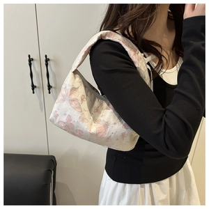 Detail of light beige pillow bag with pink butterfly prints and wide shoulder strap
