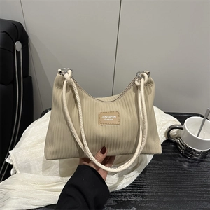 Minimalist pleated stripe tote bag in beige with braided rope handles and woven texture