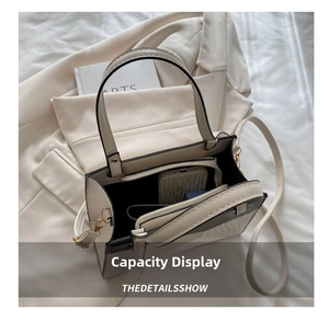 Top view showing the spacious interior compartments of the cream-colored leather crossbody bag