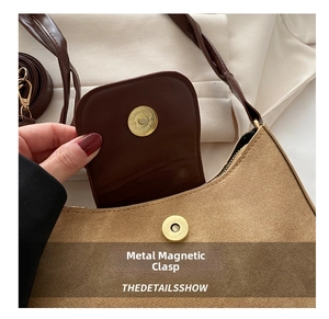 Détail du fermoir magnétique doré sur un sac bandoulière en toile beige