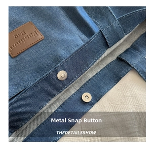 Detail of blue denim wash texture with magnetic snap and leather fashion bag logo tag