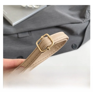 Detail of beige adjustable leather strap with golden buckle and fine stitching