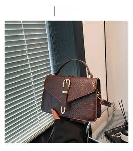 Détail du sac à main marron foncé effet crocodile avec boucle vintage et poignée chic