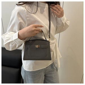 Detail of dark grey litchi grain leather bag with a golden rectangular twist lock