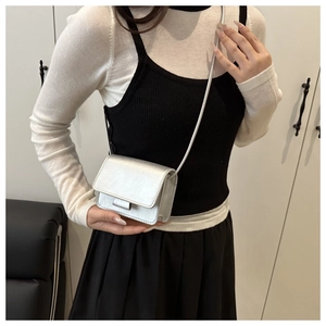 Detail of silver mini crossbody bag for girls with metallic finish and long shoulder strap
