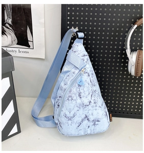 Detail of light blue marble pattern nylon chest bag with triangular zip and side label