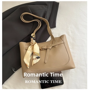Detail of beige faux leather tote bag with printed silk scarf and decorative strap buckle