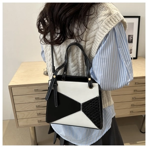 Detail of black and white geometric handbag with smooth leather and woven texture finish