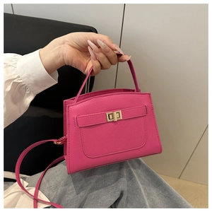 Détail du sac rose fuchsia en cuir grainé avec fermoir doré et poignée chic