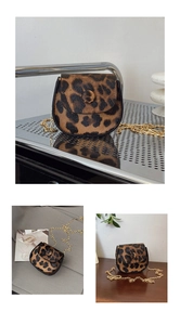 Detailed view of leopard print mini saddle bag featuring faux calf hair and gold chain strap