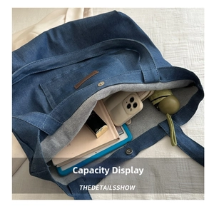 Internal view of a large capacity blue denim tote bag with daily items inside