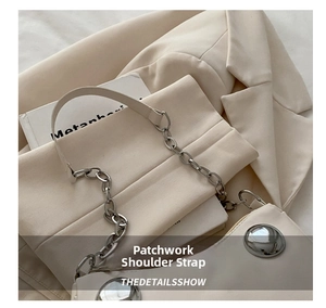 Detail of off-white dumpling bag with silver buckles and chain stitching strap