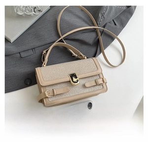 Detail of beige woven crossbody bag with gold lock and smartphone for size reference