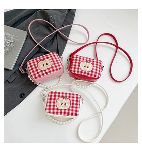 Detailed view of plaid cosmetic bags with pearl handles and cute apple embroidery