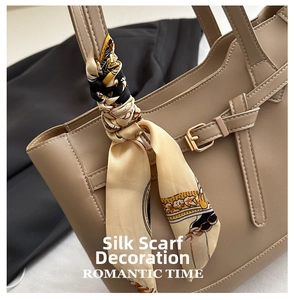Detail of beige tote bag with floral scarf handle and premium leather texture close-up