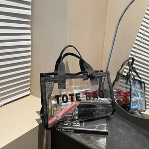 Transparent PVC tote bag with black mesh trim and bold TOTE BAG text print for storage