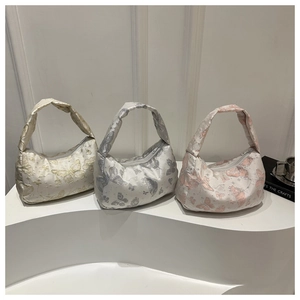 Close-up of butterfly jacquard fabric detail on elegant satin hobo handbags in three colors