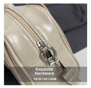 Gros plan sur la quincaillerie argentée polie et la texture du cuir crème du sac