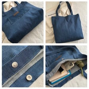 Detail showing the large capacity interior of a navy denim tote bag with magnetic clasp
