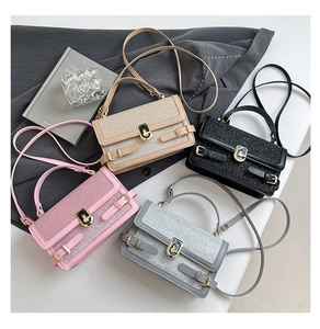 Detail of glitter texture and gold ring lock on stylish contrast color square handbag