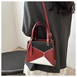Detailed back view of a geometric patchwork handbag with red black white PU leather