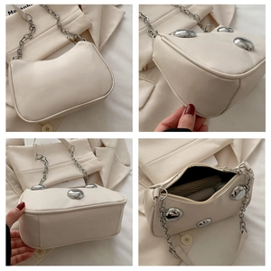 Detailed views of cream leather hobo bag with large silver studs and chain strap