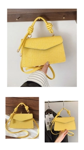 Détail d'un sac bandoulière tressé jaune avec poignée nouée et finitions métalliques