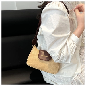 Détail du sac bandoulière en daim contrasté avec l'inscription FASHION & BAGS gravée