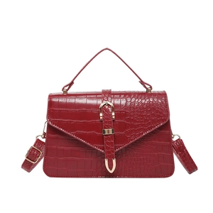 Sac à main bordeaux brillant motif crocodile avec boucle dorée et bandoulière chic