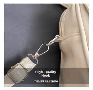 Détails du crochet en métal argenté et de la sangle réglable du sac Boston en cuir crème